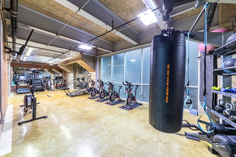 A gym with a punching bag and exercise bikes.