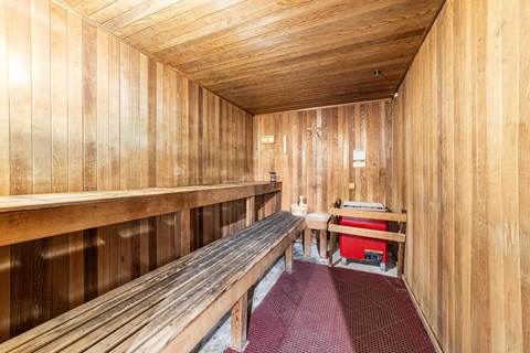 A wooden sauna with benches and a table.