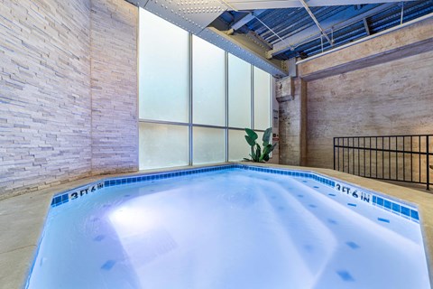 A small indoor swimming pool with a blue tiled edge.
