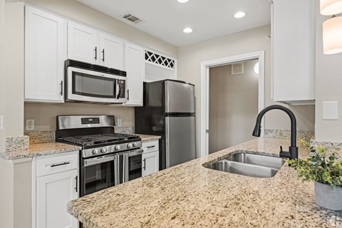 A kitchen with granite countertops and stainless steel appliances.