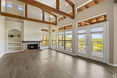 A large, empty room with wooden floors and a fireplace.