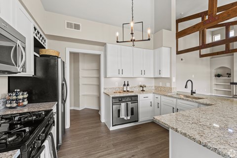 A kitchen with a black stove top oven and white cabinets.