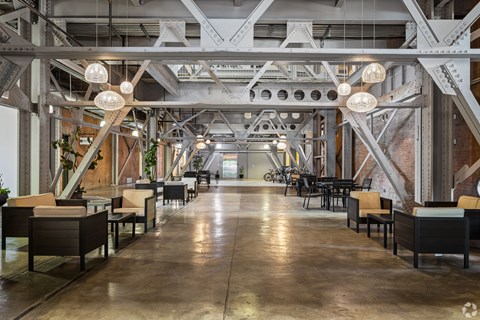 A large open space with tables and chairs under a metal framework.