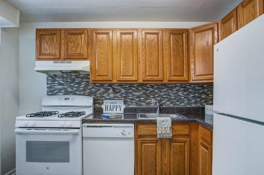 a kitchen with white appliances and wooden cabinets