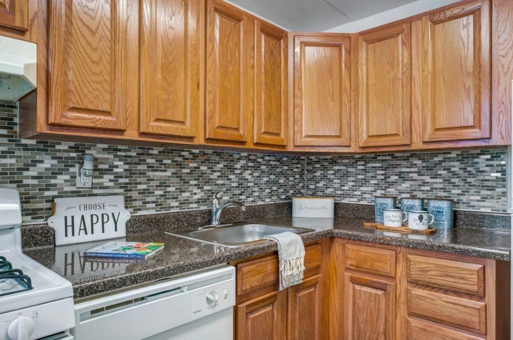 a kitchen with wooden cabinets and a sink and a stove