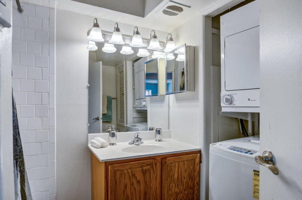 a bathroom with a sink and a mirror and a washing machine