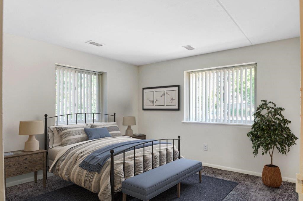 a bedroom with a bed and two windows