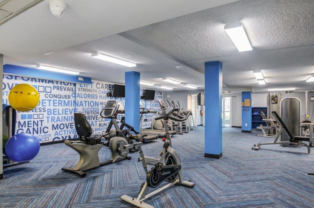 a gym with cardio machines and weights at the courtyard