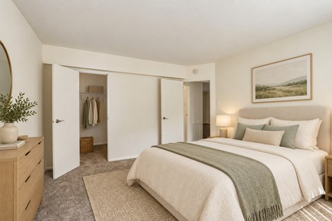A bedroom with a large bed and a painting on the wall.