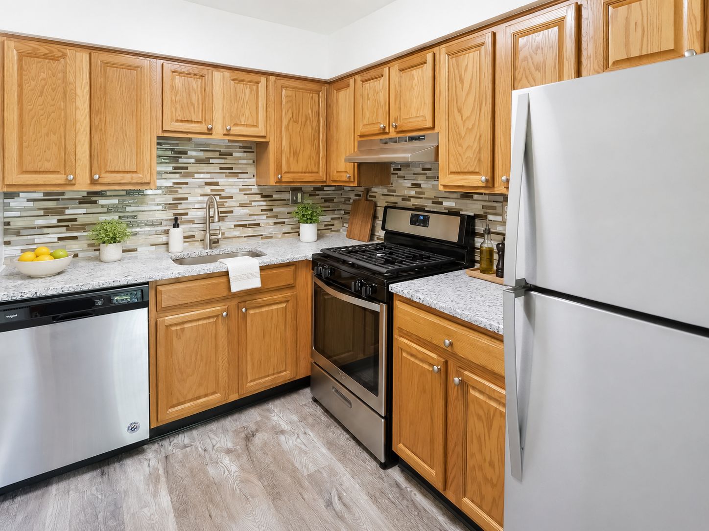 A kitchen with wooden cabinets and a white refrigerator.