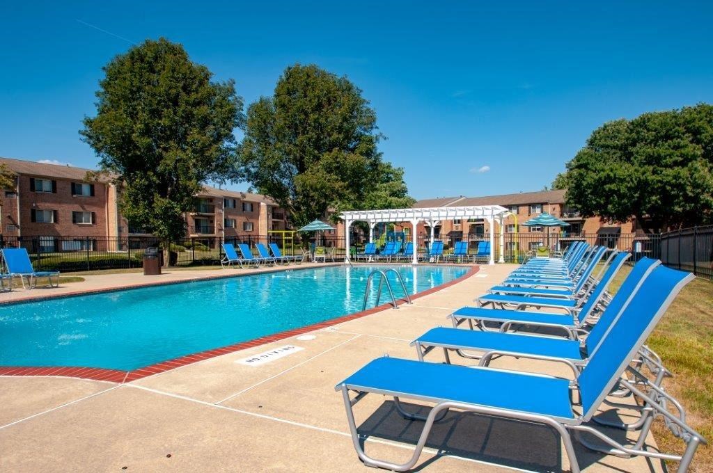 a swimming pool with blue lounge chairs next to a pool