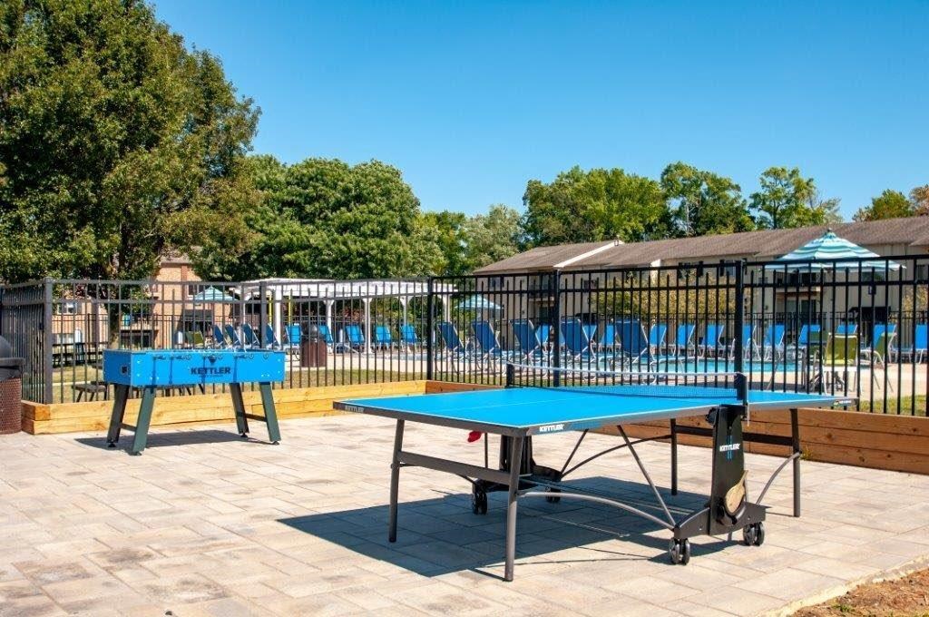 a ping pong table on a patio in front of a pool
