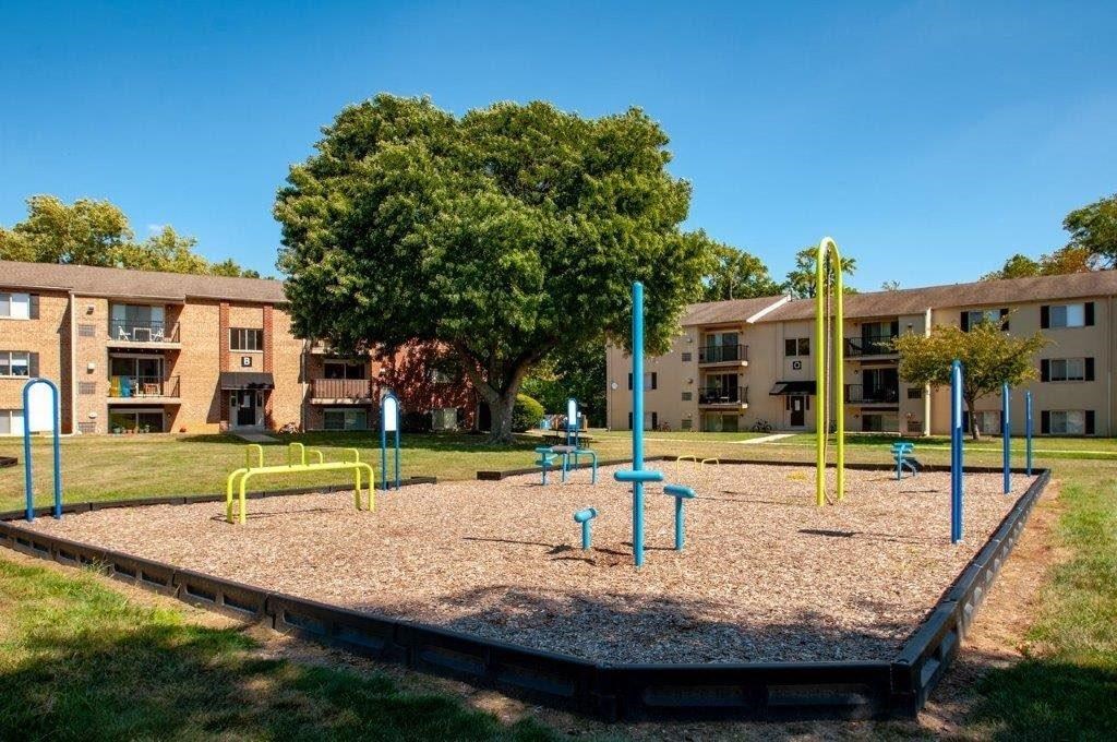 an empty playground in front of an apartment building