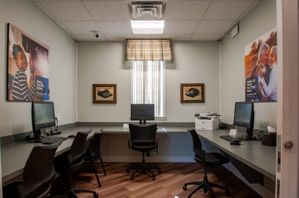 a conference room with computers and chairs and posters on the wall