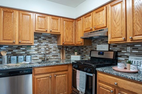 a kitchen with wooden cabinets and a stove and a sink