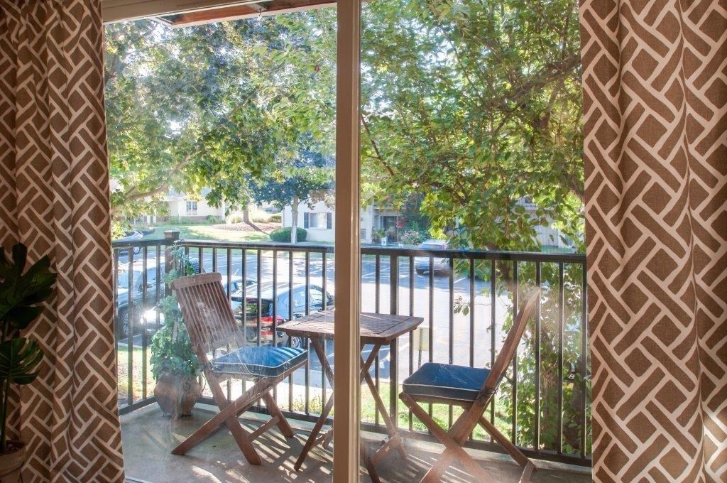 a patio with chairs and a table on a balcony