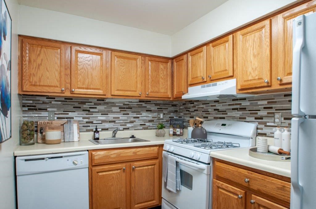 a kitchen with white appliances and wooden cabinets