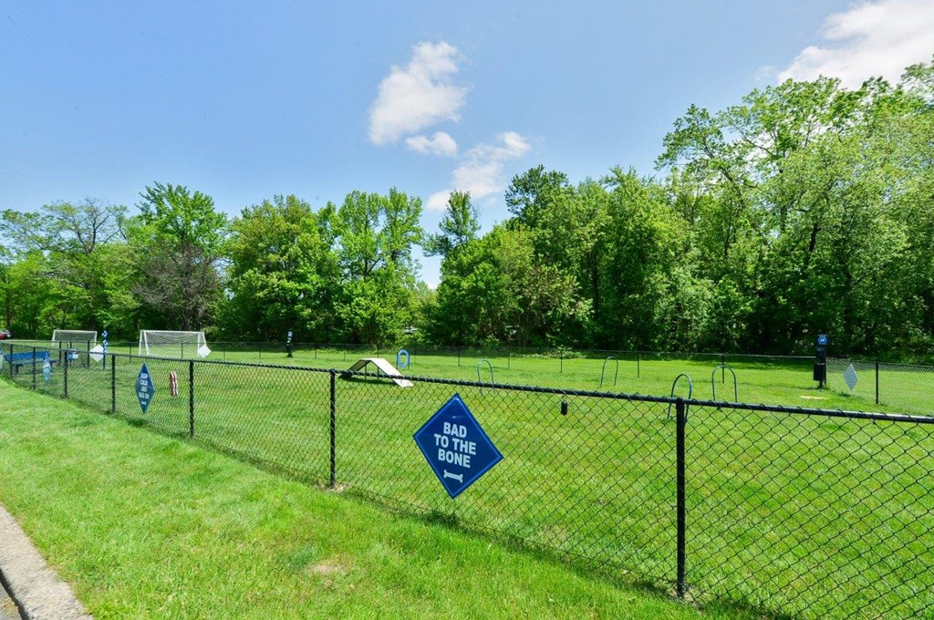 a soccer field with a sign on a chain link fence