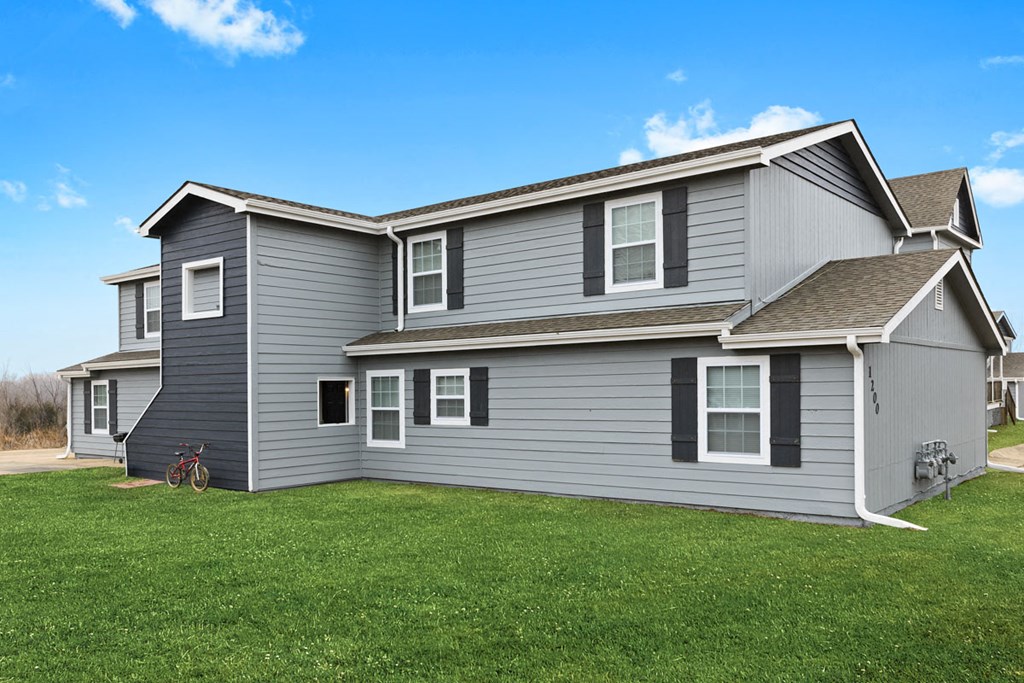 a gray house with a yard in front of it