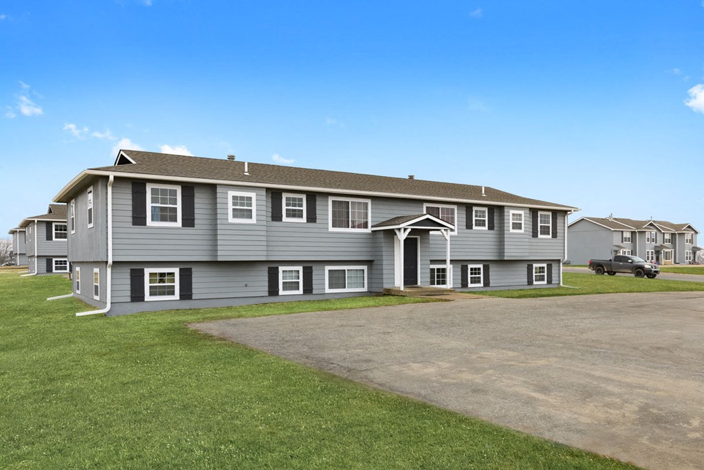 a large gray house with a driveway in front of it