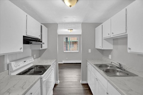 a kitchen with white cabinets and a sink and a stove