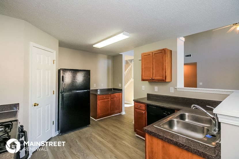 a kitchen with a black refrigerator and a sink
