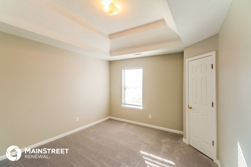 the upstairs bedroom with a door to the closet and a window