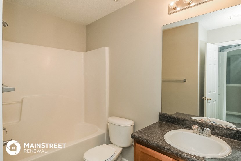 a bathroom with a sink toilet and a mirror