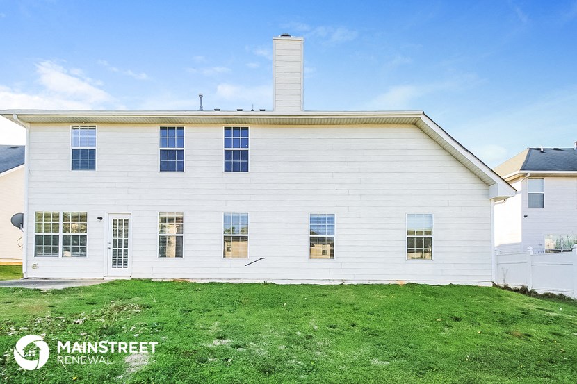 a white house with a green lawn and a blue sky