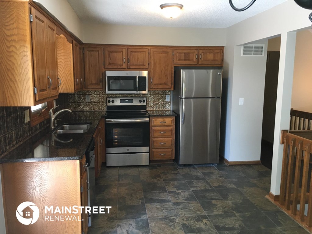 a kitchen with wooden cabinets and stainless steel appliances
