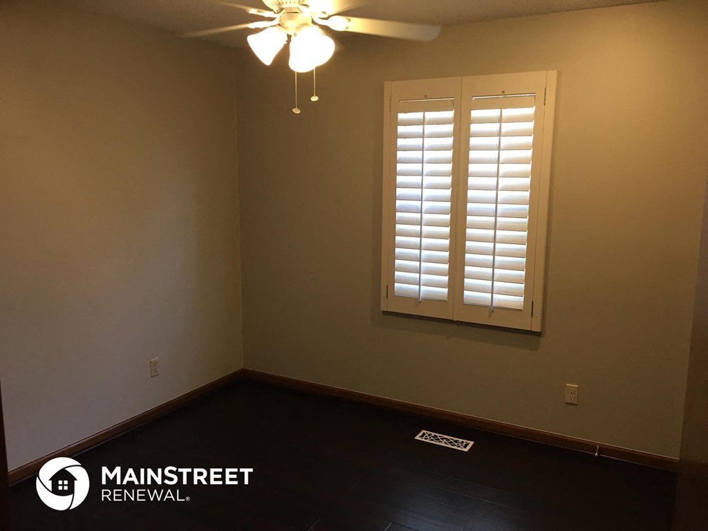 a empty room with a window and a ceiling fan