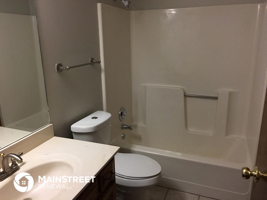 a bathroom with a toilet and a tub and a sink