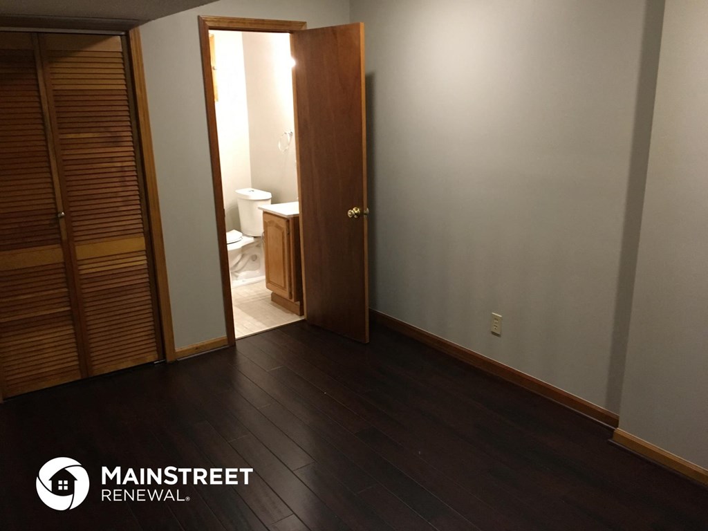 an empty room with a door open to a bathroom