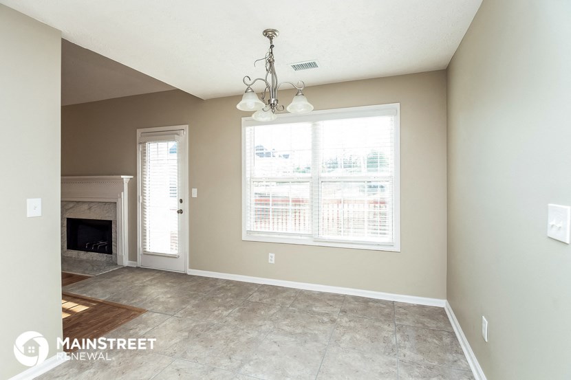 a living room with a large window and a cement floor