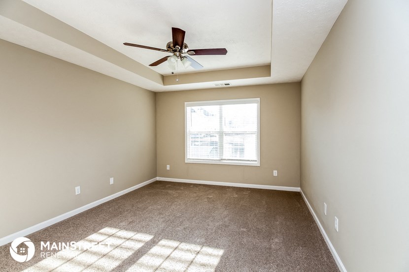 the master bedroom is spacious and has a ceiling fan