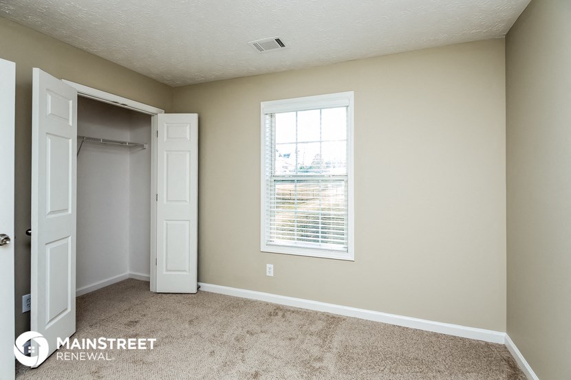 a bedroom with a closet and a window and a door