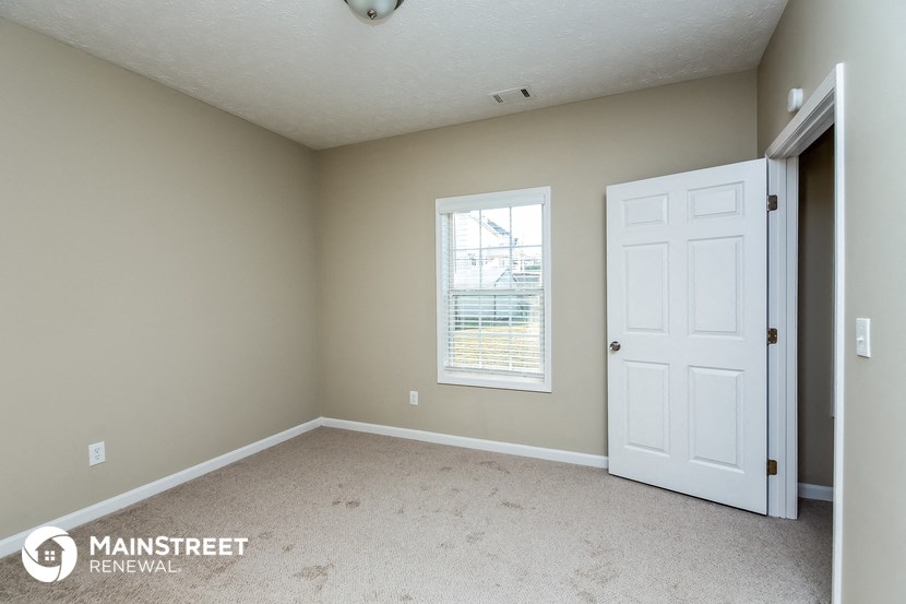 a bedroom with a white door and a window