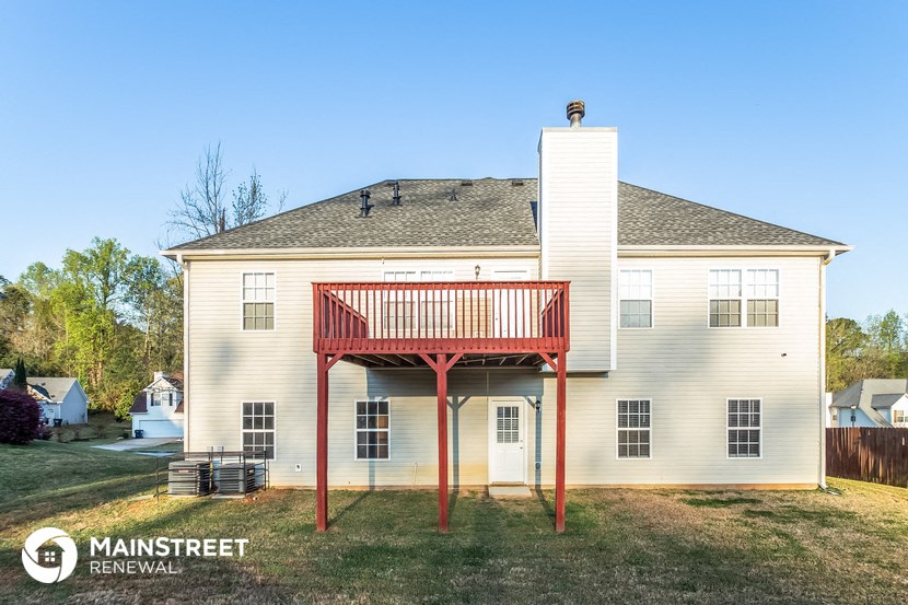 a white house with a deck and a red porch