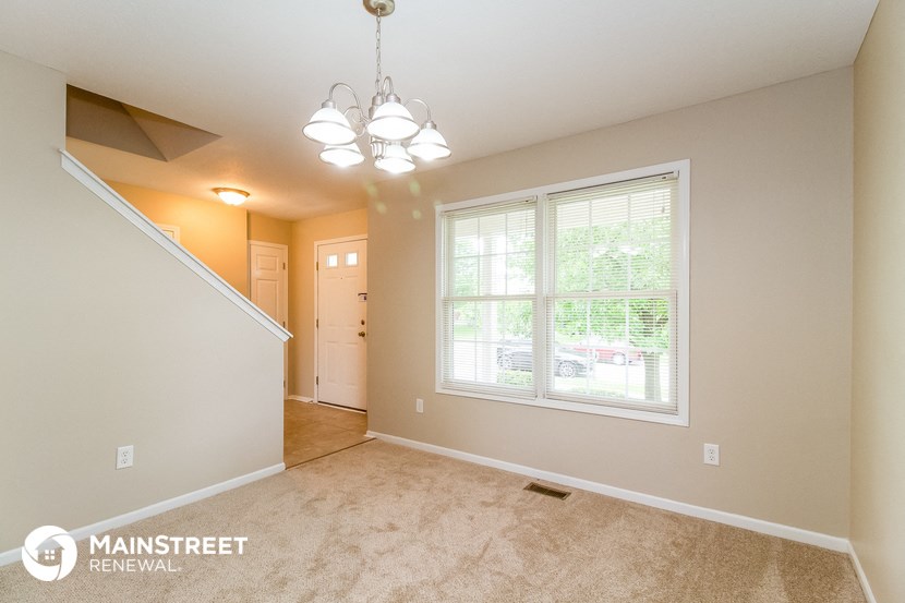 the living room and dining room of a house with a large window