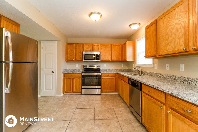 a kitchen with wooden cabinets and stainless steel appliances and granite counter tops