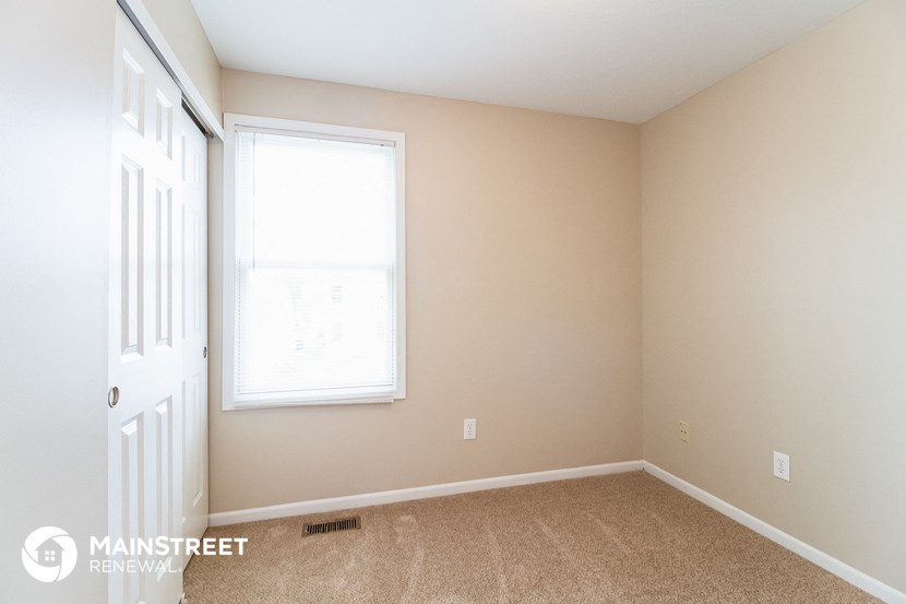 an empty room with a window and a door