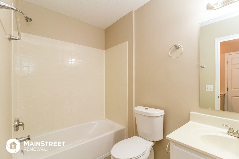 a bathroom with a toilet and a tub and a sink