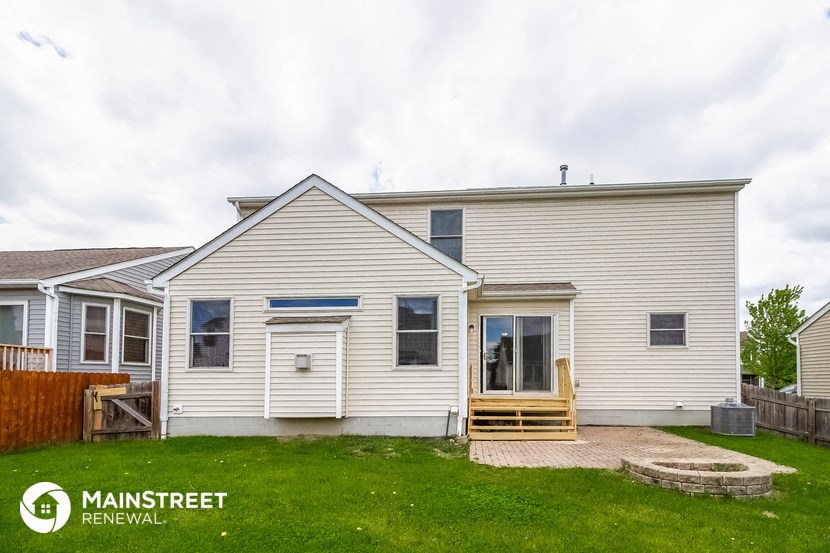 the exterior of a white house with a porch and a deck