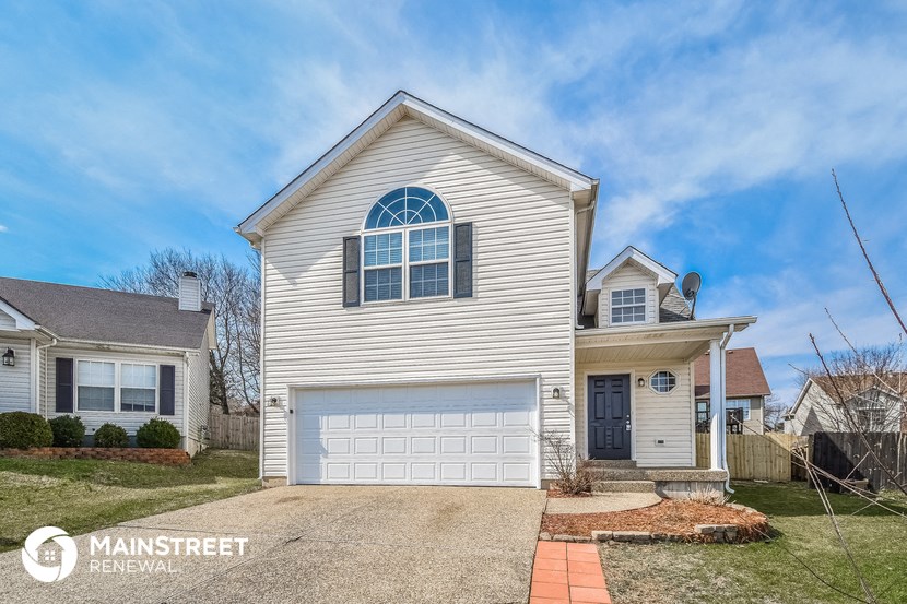 a white house with a white garage door and a blue sky
