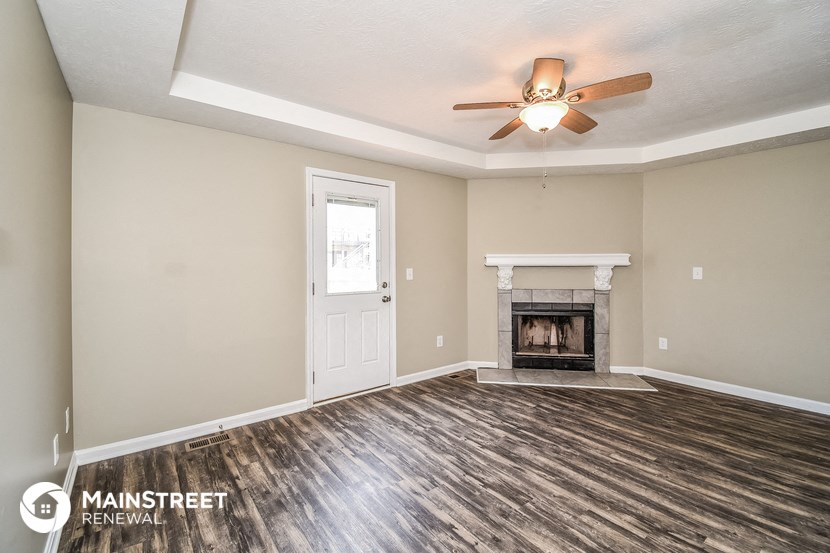 the living room with fireplace and ceiling fan
