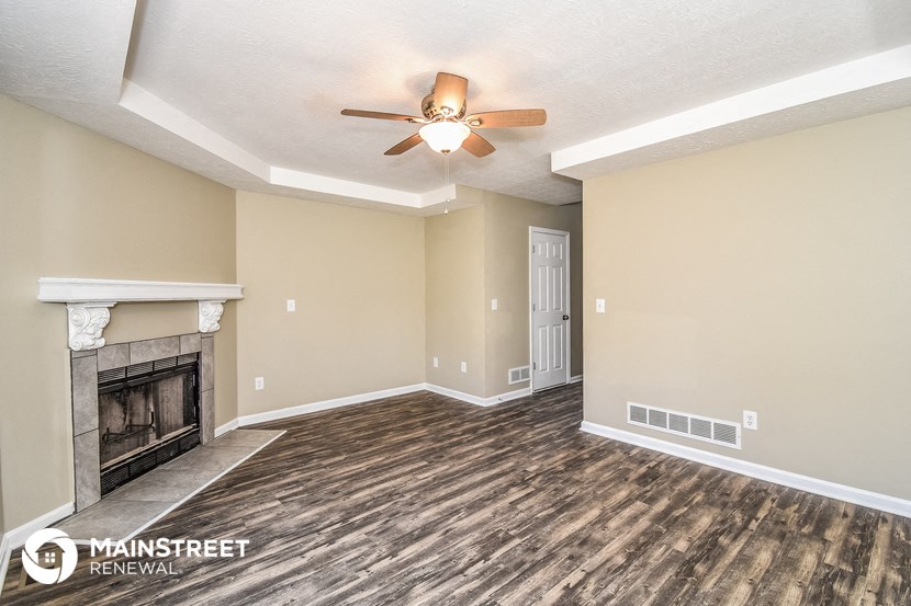 the living room with fireplace and ceiling fan