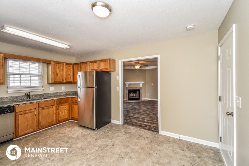 a kitchen with wooden cabinets and a stainless steel refrigerator