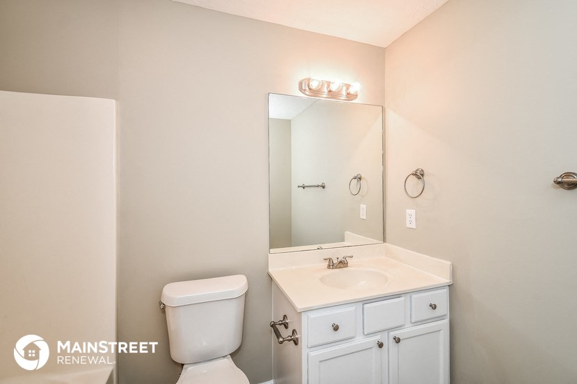 a bathroom with a white sink and toilet and a mirror