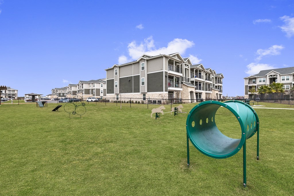 a dog park with houses in the background