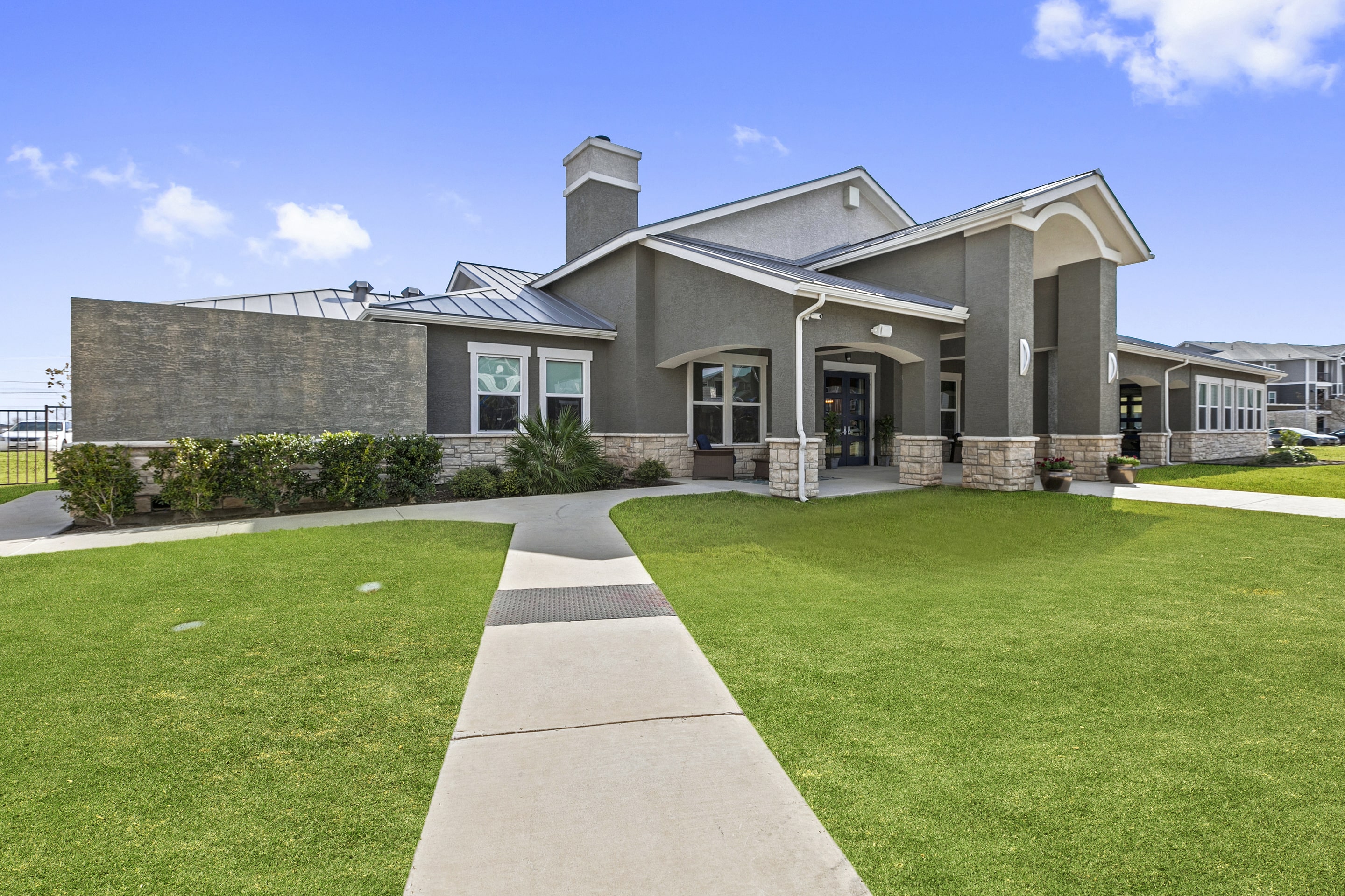 a large house with a lawn and sidewalk in front of it